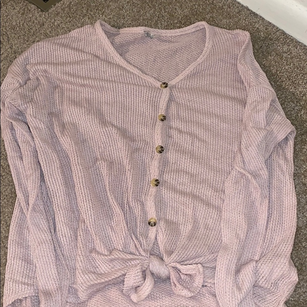 A light pink sweater with a cute bow at the end